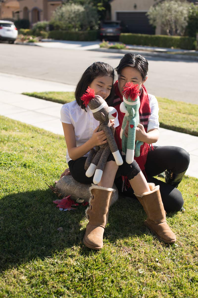 Two girls holding 6-inch Sock Monkey in different colors, huggable vintage toy with soft plush fabric by Plushland