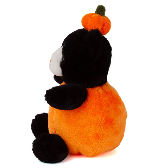 Side view of a black cat plush wearing a round orange pumpkin costume